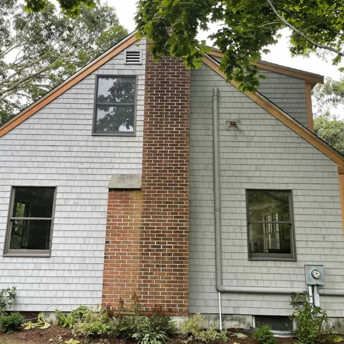 Shingle siding beside a brick chimney