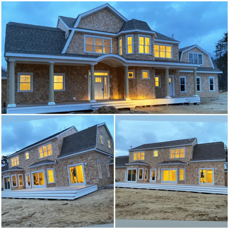 Shingled home at dusk with lit windows