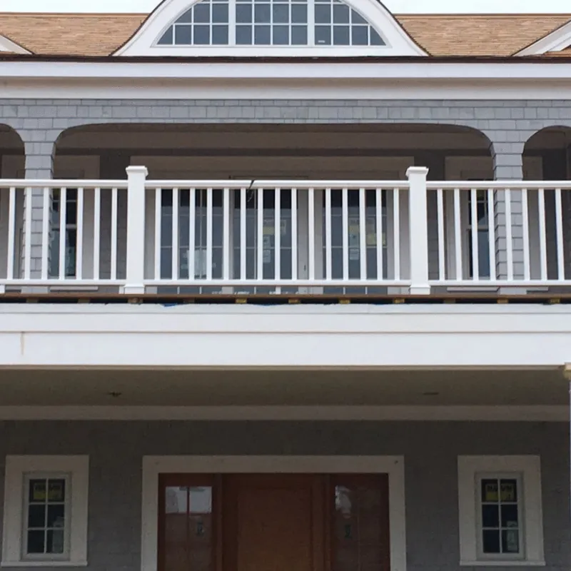 White-railed porch above a paneled entry